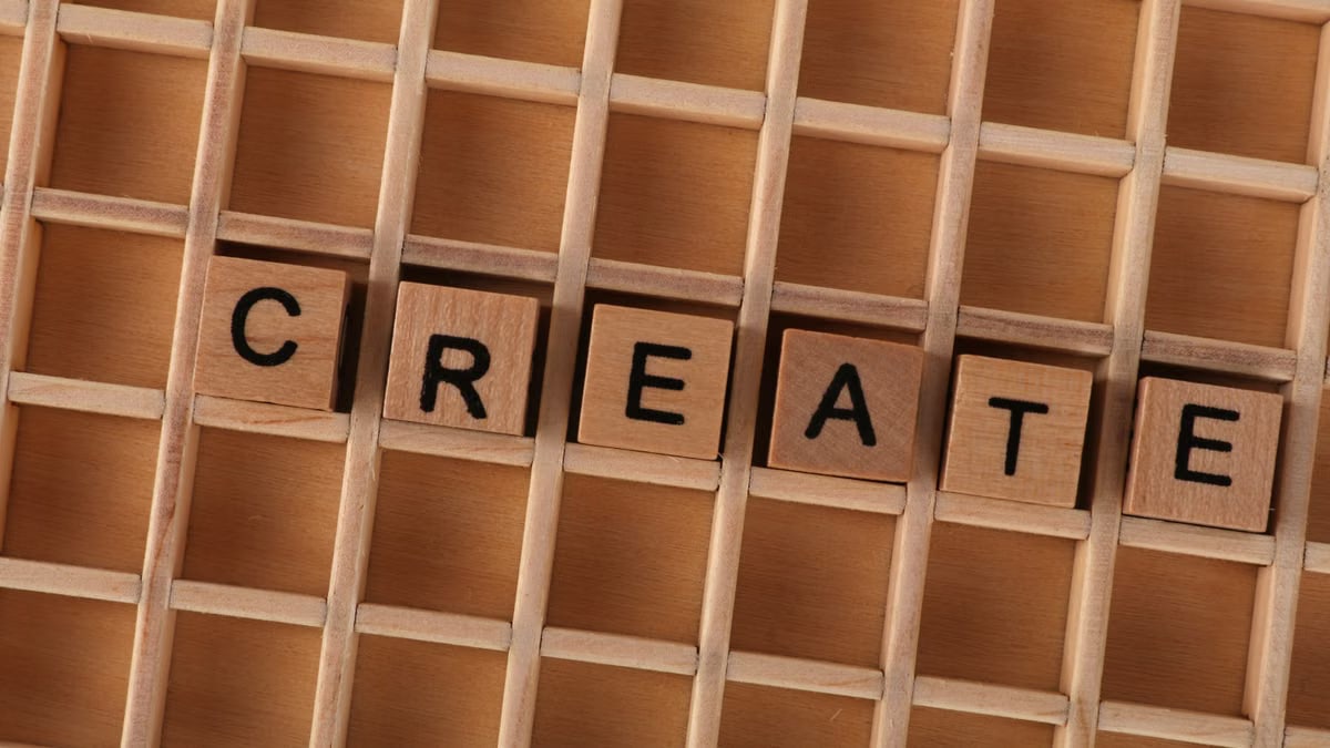 Wooden blocks in a grid forming the word CREATE, conveying creativity and innovation.